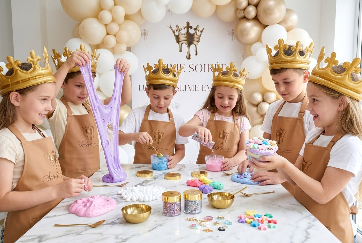 Six children in gold crowns and Slime Soirée aprons making purple and pink slime at a marble party table